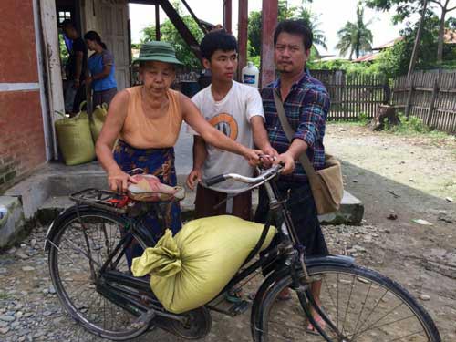 A Buddhist woman carrying rice on her bike 