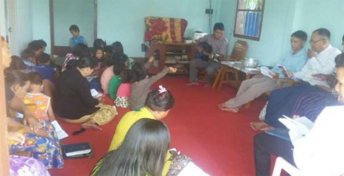 Bro. David Tun Win leading Sunday worship service by playing guitar